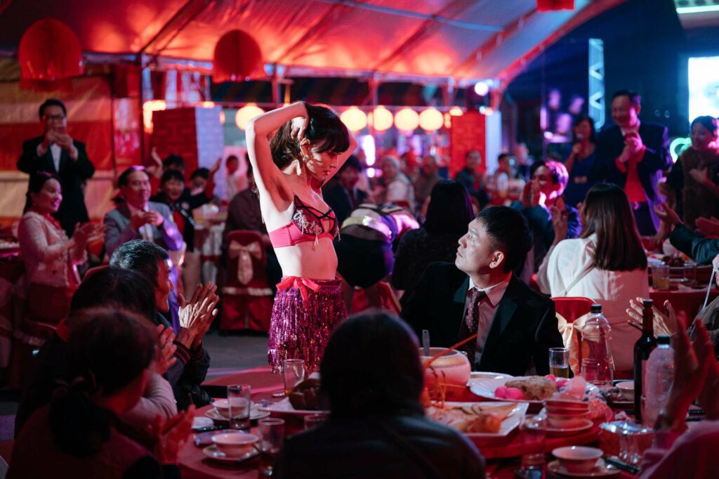 春風與姚以緹飾演的電子花車女郎有著糾葛的複雜關係。（圖：英傑哆影業提供）