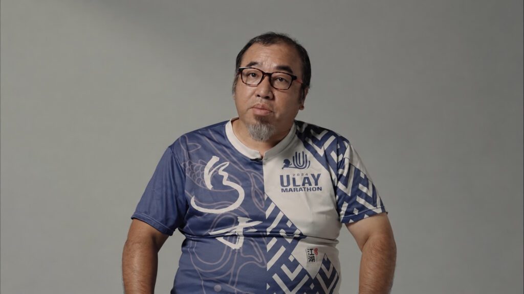 身穿烏來馬拉松賽衣的監製邵敬一，也是跑者口中的邵老師。（圖片來源：預告片截圖）